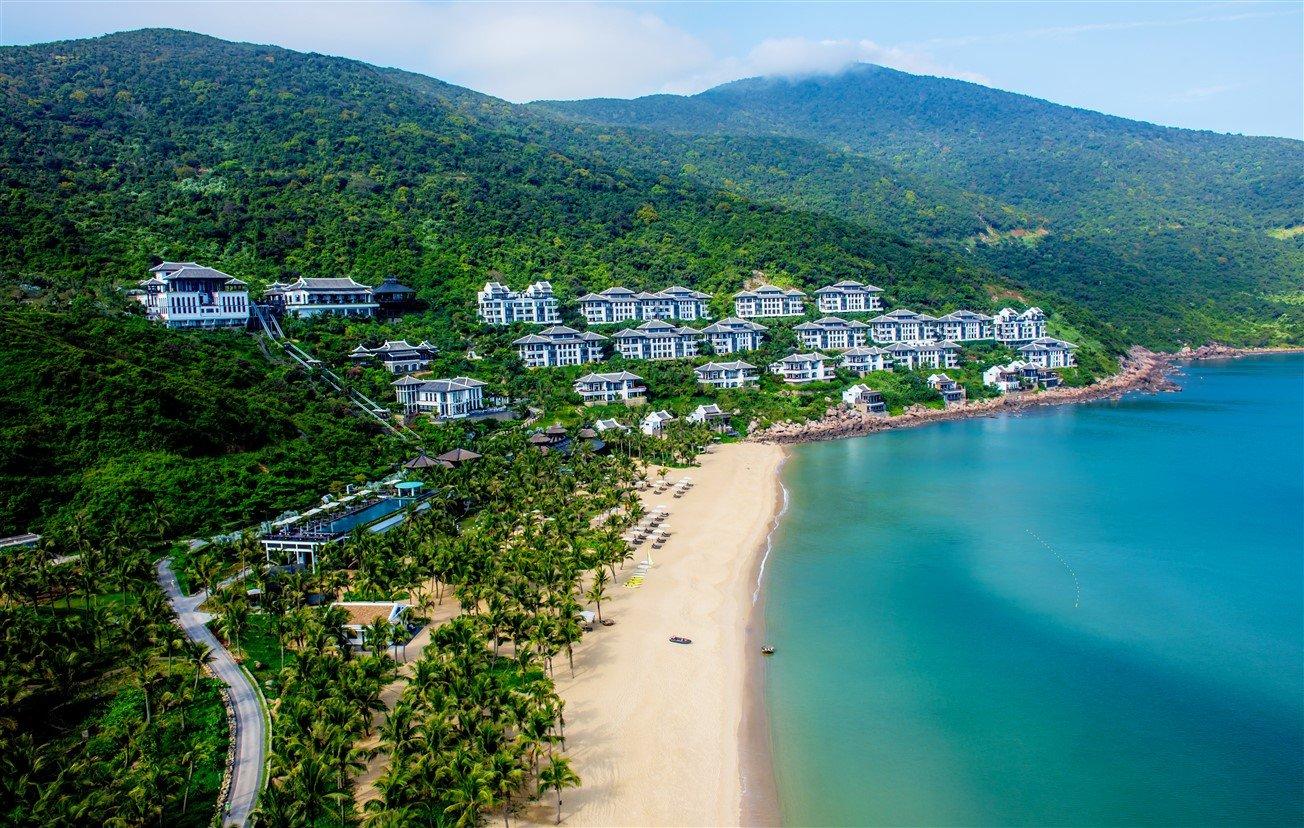 Secluded sandy beach with clear water and rocky coastline in central Vietnam.