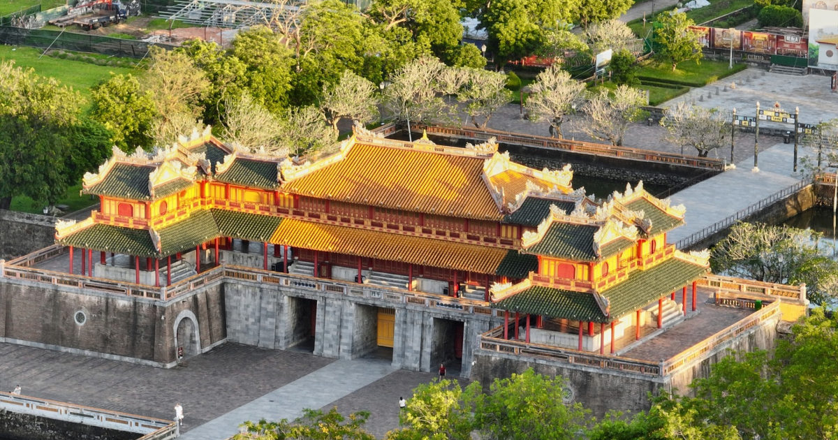 The Citadel's vermilion walls gleam under Hue's misty morning sun