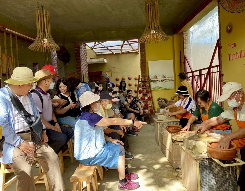 Visitor carrying water while exploring outdoor village