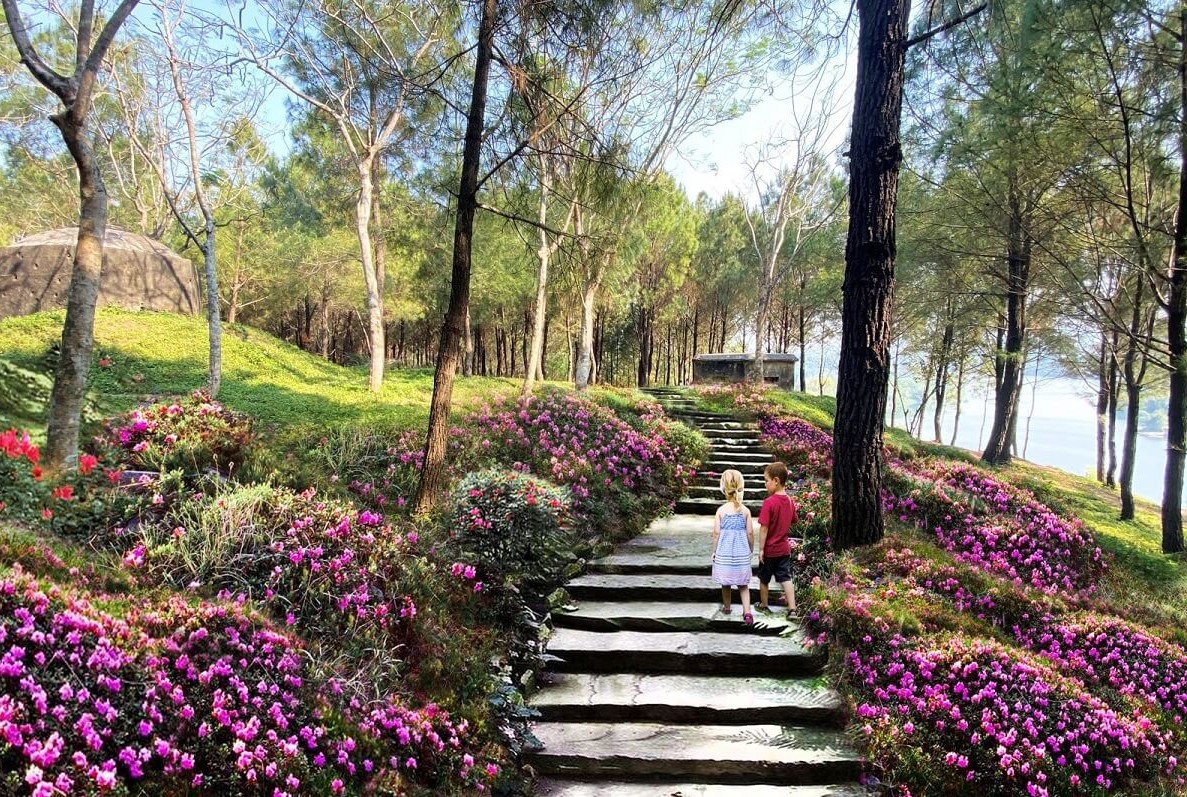Visitors taking photographs at a scenic viewpoint in Hue