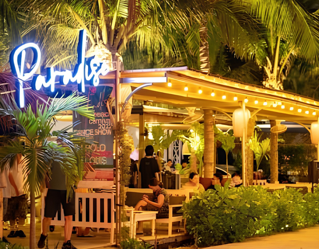 Paradise Beach Bar combines food, drinks, beach seating, and evening entertainment by the coast.