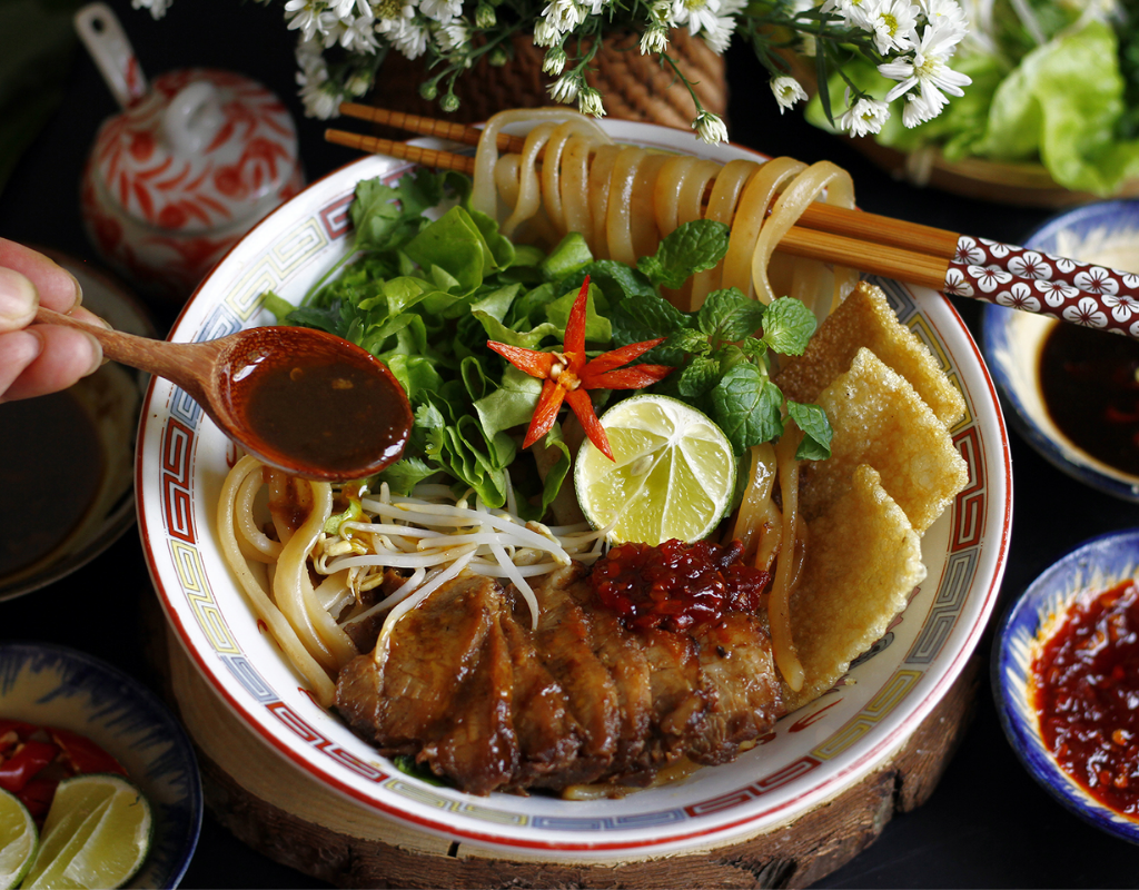 Cao Lau – Hoi An's signature noodle dish with chewy noodles, roasted pork, fresh herbs, and crispy crackers.